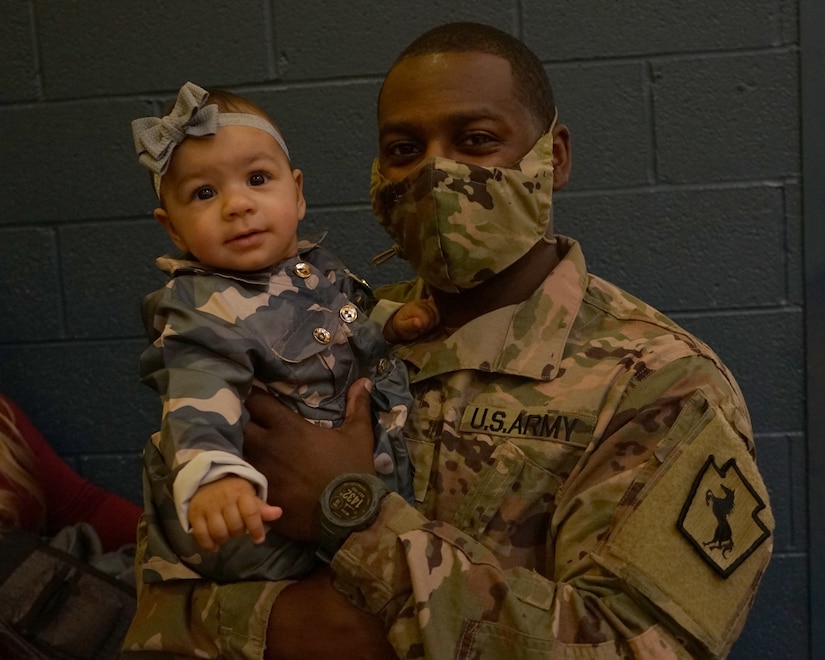 A Soldier from the 228th Engineer Company, 337th Engineer Battalion, 55th Maneuver Enhancement Brigade, spends time with his family before the deployment departure ceremony at Northern Lebanon High School on October 12, 2021. The Soldiers were supported by friends, family, and fellow service members, that attended to support the Soldiers of the 228th on their mission (U.S. Army photo by Sgt. 1st Class Matthew Keeler).