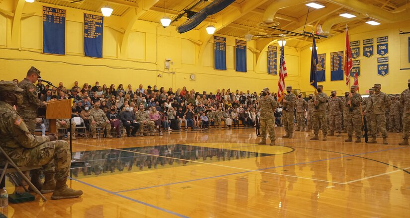 (left) Capt. James Goslin, commander of the 228th Engineer Company, discusses the strength of the Soldiers and leaders of the company during their deployment departure ceremony at North Lebanon High School on October 10, 2021. The Soldiers were supported by friends, family, and fellow service members, that attended to support the Soldiers of the 228th on their mission (U.S. Army photo by Sgt. 1st Class Matthew Keeler).