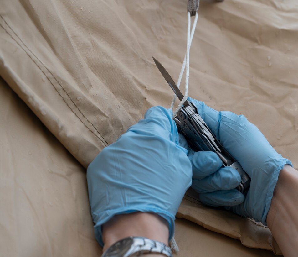 U.S. Air Force Airman 1st Class Kyle Hunter, 86th Aircraft Maintenance Squadron crew chief, cuts a zip tie at Ramstein Air Base, Germany, Oct. 14, 2021. Afghanistan evacuation operations at Ramstein are nearing a close after nearly two months of caring for and housing evacuees. (U.S. Air Force photo by Senior Airman Thomas Karol)