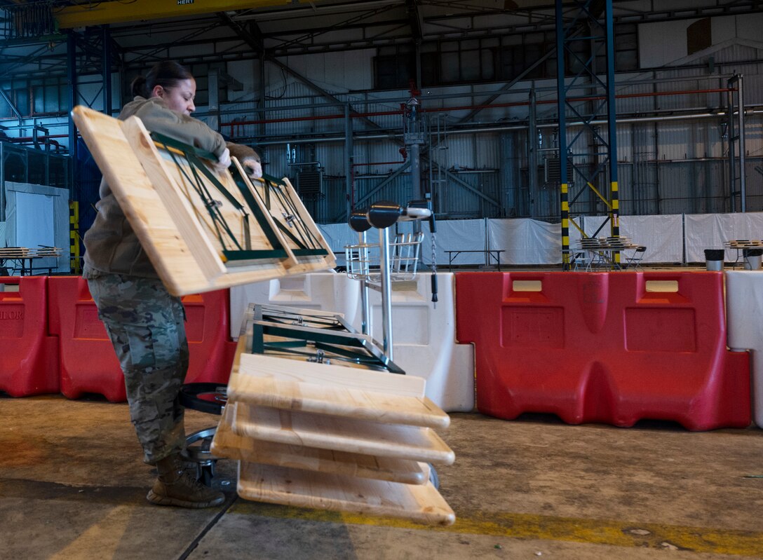 U.S. Air Force Master Sgt. Claudia Loera, U.S. Air Forces in Europe headquarters training manager, stacks tables at Ramstein Air Base, Germany, Oct. 14, 2021. More than 34,800 evacuees have departed Ramstein during Afghanistan evacuation operations. Since operations are coming to a close with only 2,500 currently awaiting travel. (U.S. Air Force photo by Senior Airman Thomas Karol)