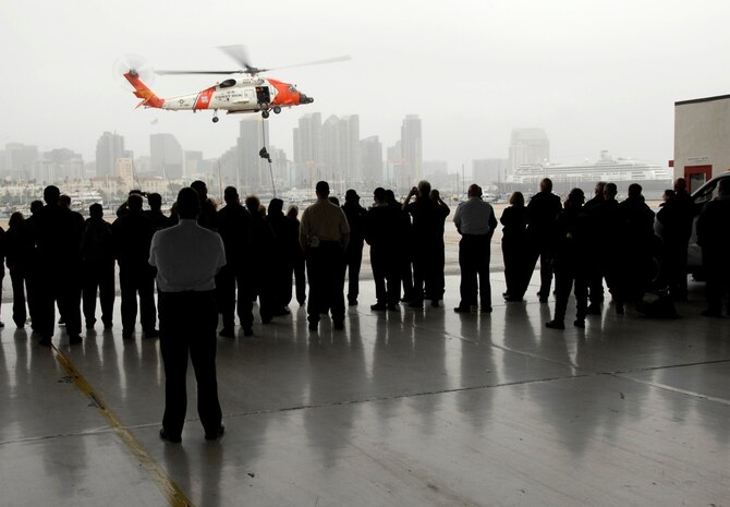 Participants of the Department of Defense's Executive Leadership Development Program watch as Maritime Safety and Security Team San Diego members demonstrate a vertical insertion at Coast Guard Sector San Diego Feb. 5, 2009. ELDP is a ten-month program designed to help future department leaders become better acquainted with the military. Members from MSST San Diego, Pacific Tactical Law Enforcement Team and Sector San Diego were on hand to demonstrate the Coast Guard's many roles and capabilities. (U.S. Coast Guard photo/ PA3 Henry G. Dunphy)