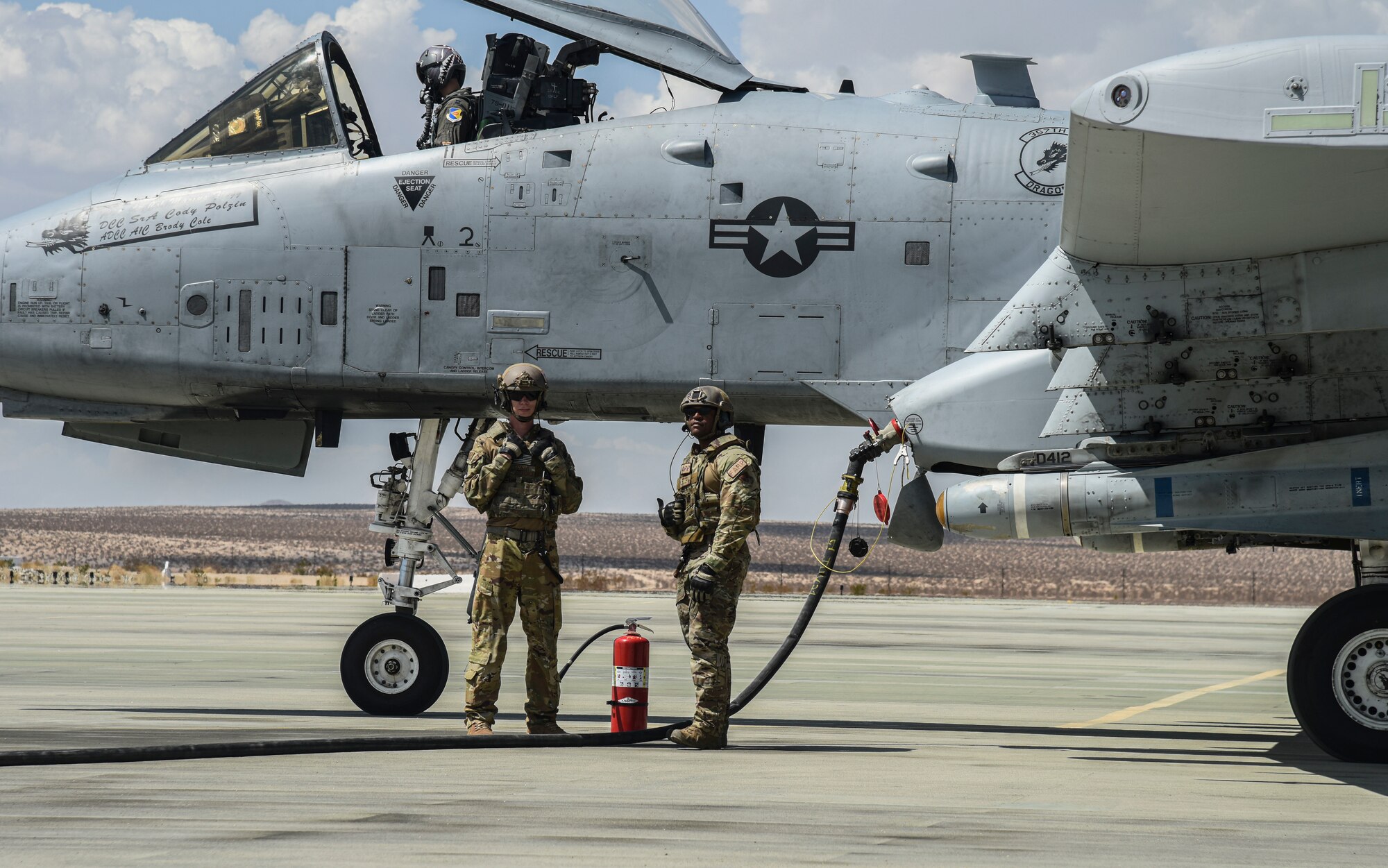 Pictured above are two Airmen standing in front of an aircraft that is refueling.