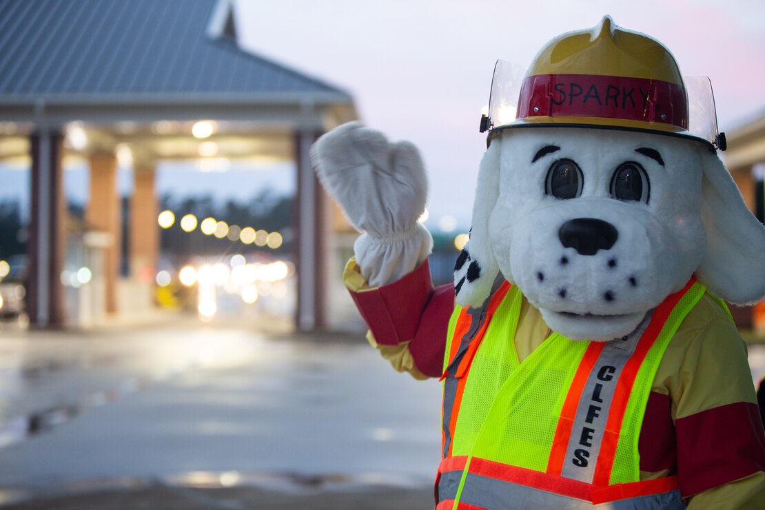 “Sparky,” the mascot for Camp Lejeune Fire and Emergency Services Division, waves in front of the Wilson gate to kick off fire prevention week on Marine Corps Base Camp Lejeune, North Carolina, Oct. 4, 2021.