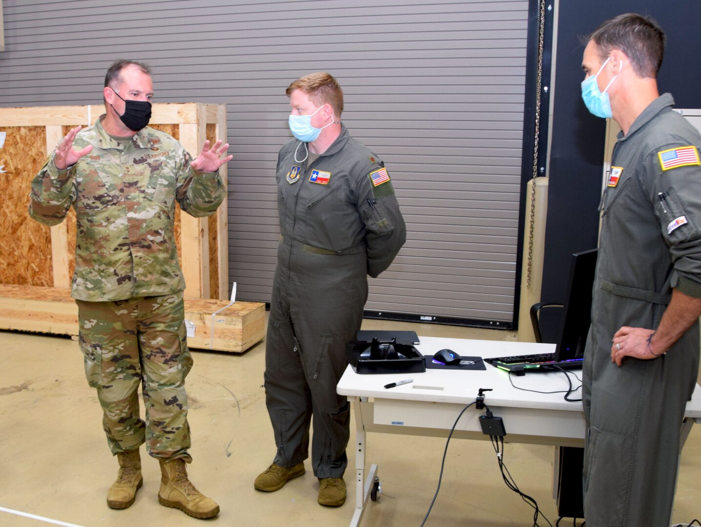 Maj. Gen. Kenneth Bibb Jr. 18th Air Force commander, talks with Maj. Paul Lentz, 733rd Training Squadron student flight commander, and Senior Master Sgt. Brian Mizula, 733rd TRS superintendent, prior to a C-5 Formal Training Unit virtual reality training demonstration, Oct. 14, 2021, at Joint Base San Antonio-Lackland, Texas. (U.S. Air Force photo by Lt. Col. Tim Wade)