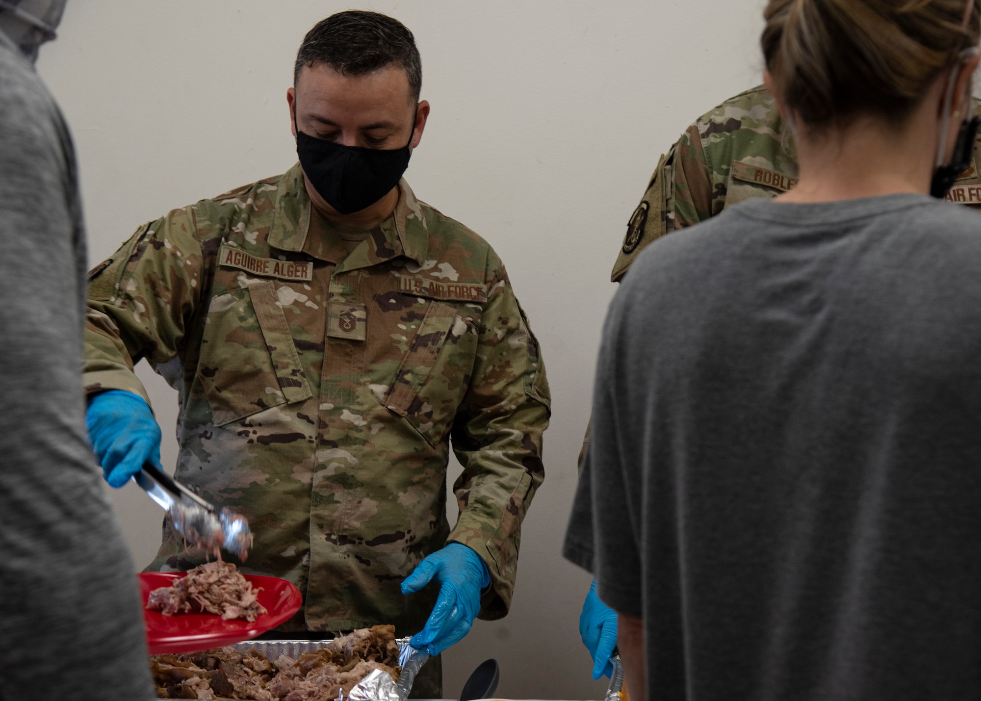 U.S. Air Force Senior Master Sgt. Juan Aguirre-Alger, 6th Force Support Squadron career assistance advisor, serves food during a Hispanic Heritage Month celebration at MacDill Air Force Base, Florida, Oct. 14, 2021.