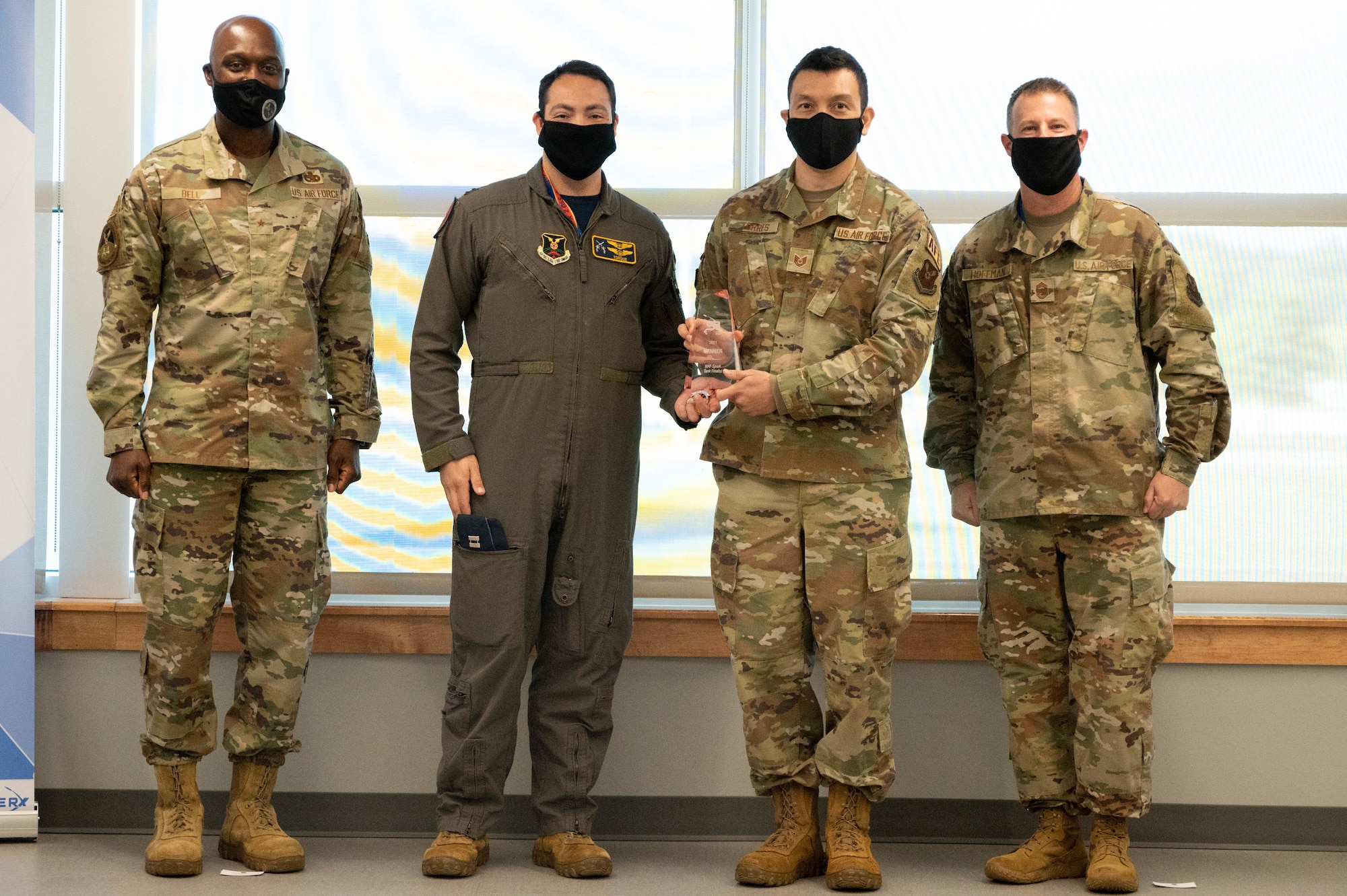 Captain Robert Moran, 2nd Operational Support Squadron B-52 weapon systems officer, and Tech. Sgt. Julio Torres, non-commissioned officer of quality assurance, stand between Brig. Gen. Kenyon Bell, director, Logistics and Engineering, Air Force Global Strike Command, and Chief Master Sgt. Charles Hoffman, AFGSC command chief, with his trophy at STRIKEWERX Spark Sprint competition Friday, Oct. 15. Moran and Torres’ innovative idea will advance to the 2022 Air Force Spark Tank competition representing AFGSC. (U.S. Air Force photo by Tech. Sgt. Will Bracy)