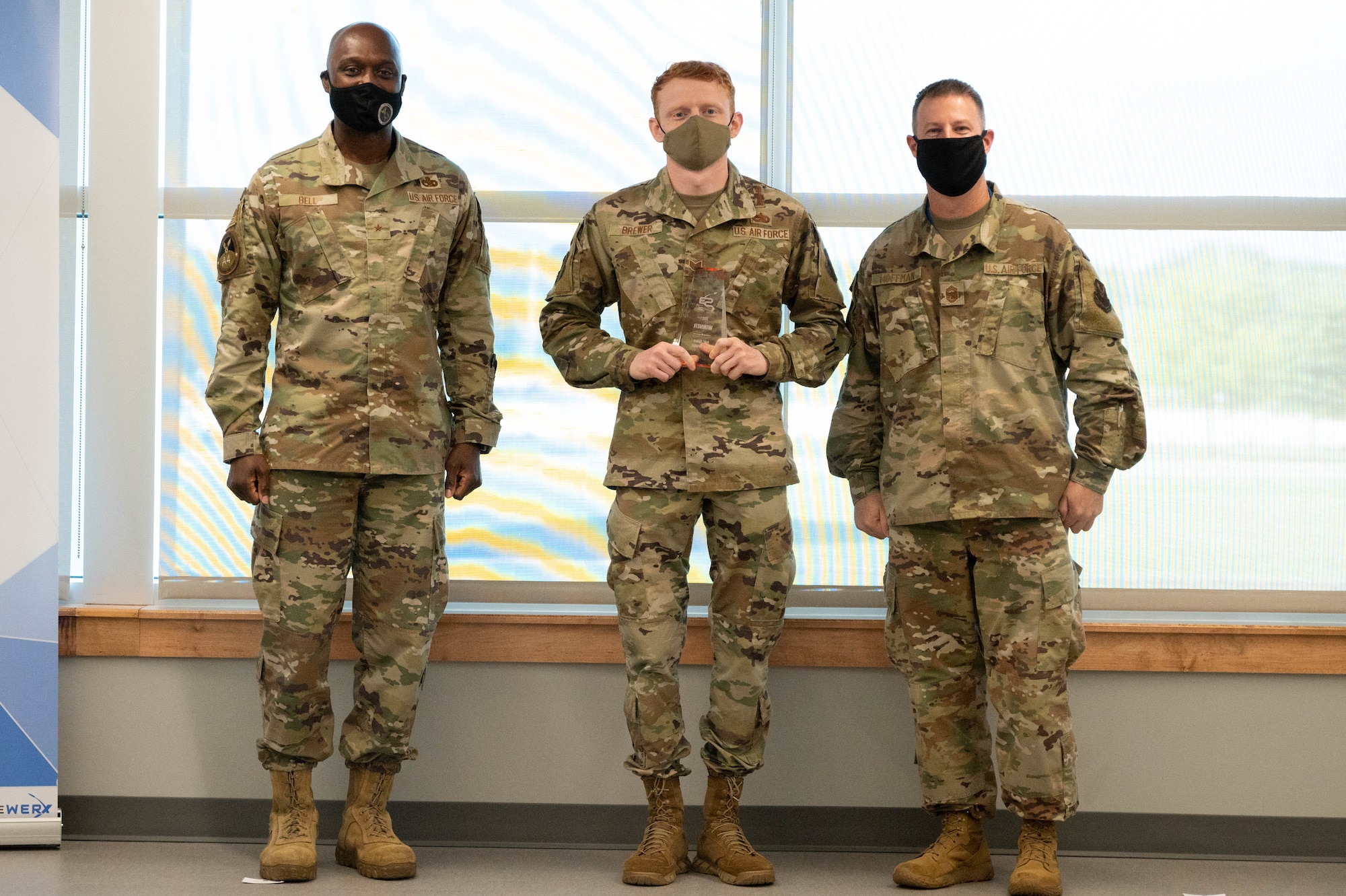 Staff Sgt. Daniel Brewer, 7th Aircraft Maintenance Squadron deputy director, Rapid Capabilities office, stands between Brig. Gen. Kenyon Bell, director, Logistics and Engineering, Air Force Global Strike Command, and Chief Master Sgt. Charles Hoffman, AFGSC command chief, with his trophy at STRIKEWERX Spark Sprint competition Friday, Oct. 15.  Brewer is one of two winners who will advance to the 2022 Air Force Spark Tank competition representing AFGSC. (U.S. Air Force photo by Tech. Sgt. Will Bracy)