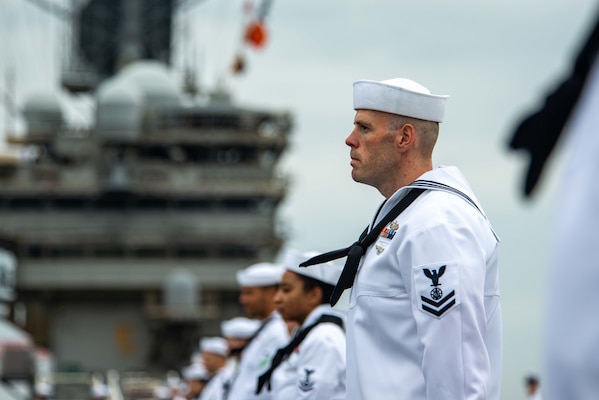 Religious Program Specialist 2nd Class Austin Bullock mans the rails as USS Ronald Reagan (CVN 76) returns to Fleet Activities Yokosuka from a five-month deployment.