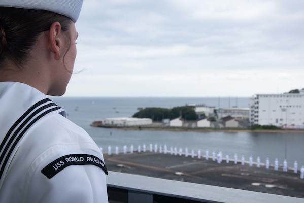 211016-N-RF825-1016 YOKOSUKA, Japan (Oct. 16, 2021) Airman Paige Boykin, from Orlando, Florida, mans the rails on as the U.S. Navy’s only forward-deployed aircraft carrier USS Ronald Reagan (CVN 76) returns to Commander, Fleet Activities Yokosuka from a five-month deployment. During Ronald Reagan’s deployment, the ship transited 43,000 nautical miles operating in the U.S. 5th Fleet area of operations to assist with Operation Freedom’s Sentinel and Operation Allies Refuge in support of U.S. drawdown operations in Afghanistan. Ronald Reagan returned to the U.S. 7th Fleet area of responsibility and took part in multi-carrier operations, which included 15,000 sailors from six partner nations upholding collective maritime interests in the Indo-Pacific region. (U.S. Navy photo by Mass Communication Specialist 2nd Class Jason Tarleton)