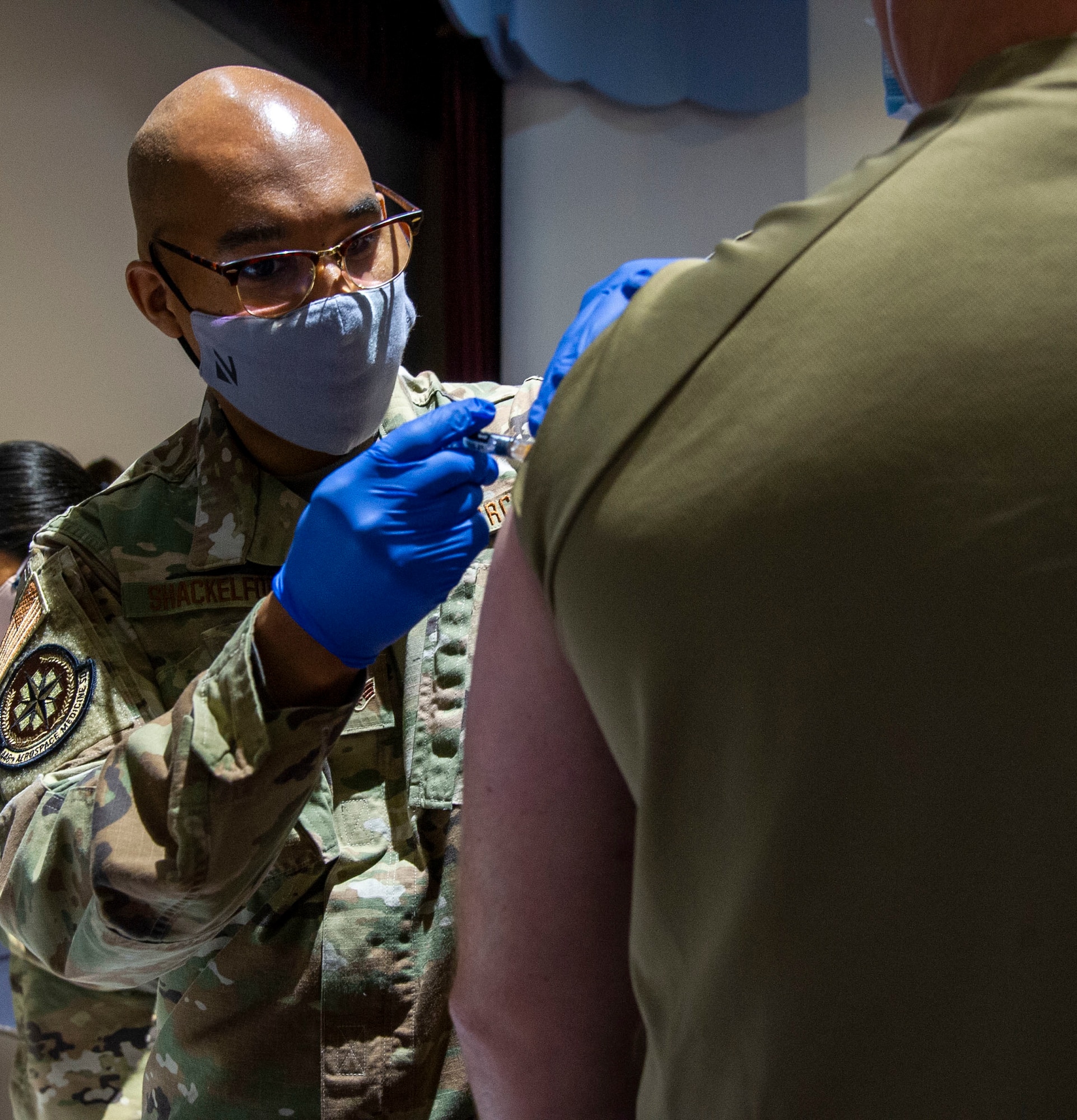 Airman administers flu vaccine to service member.