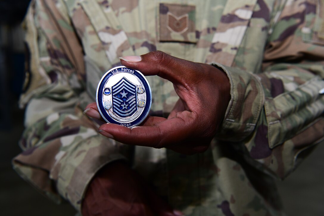 Tech. Sgt. Steven Green displays a challenge coin received from Chief Master Sgt. Wendell Snider