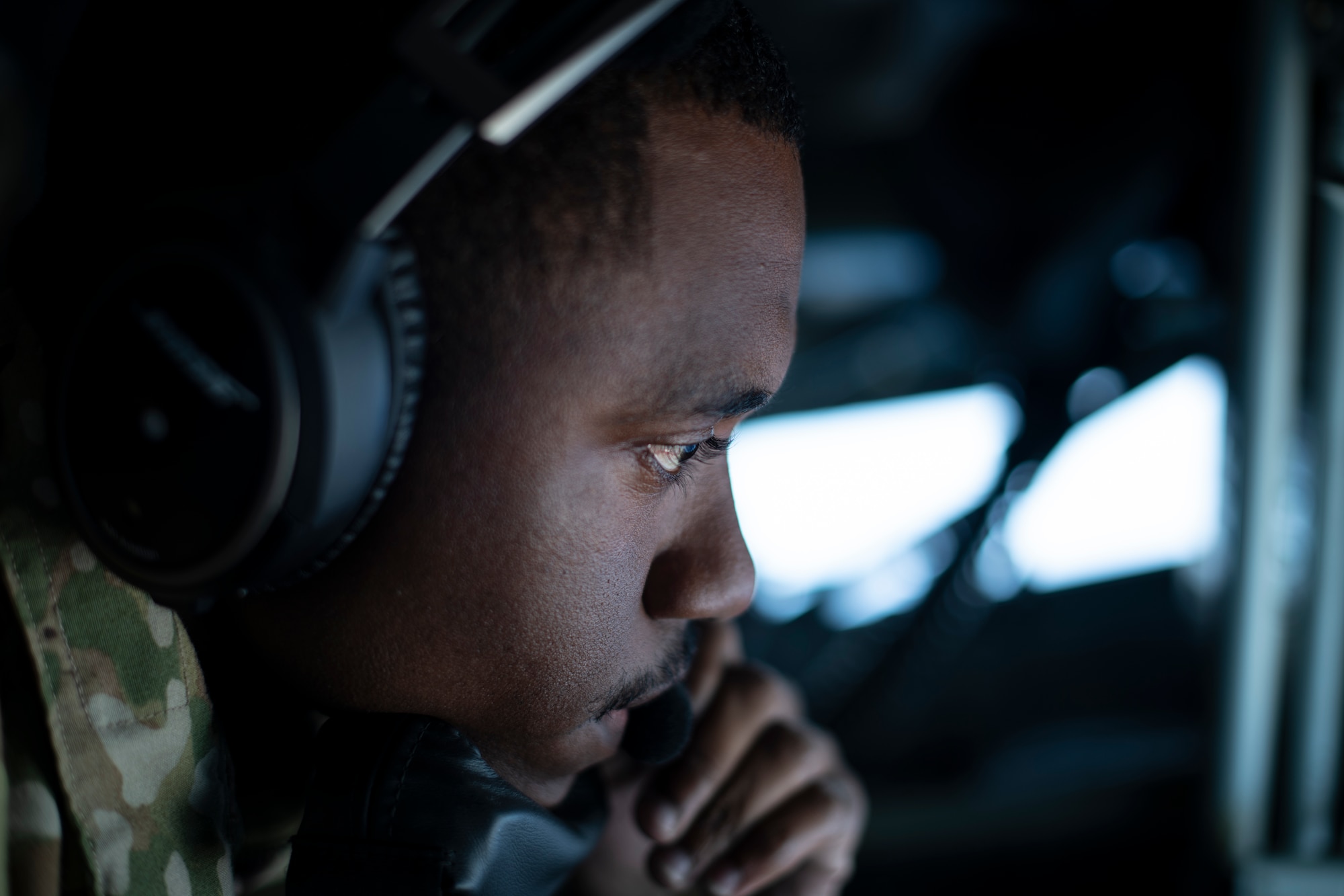 U.S. Air Force Staff Sgt. Kalif Richardson, 909th Air Refueling Squadron in-flight refueling specialist, communicates with the receiving aircraft during aerial refueling over the Pacific Ocean Oct. 14, 2021. Also known as boom operators, in-flight refueling specialists transfer thousands of gallons of jet fuel into airborne aircraft. (U.S. Air Force photo by Senior Airman Jessi Monte)