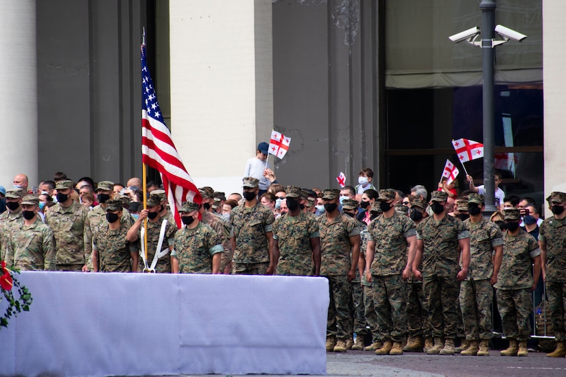 Marines and soldiers stand at attention.