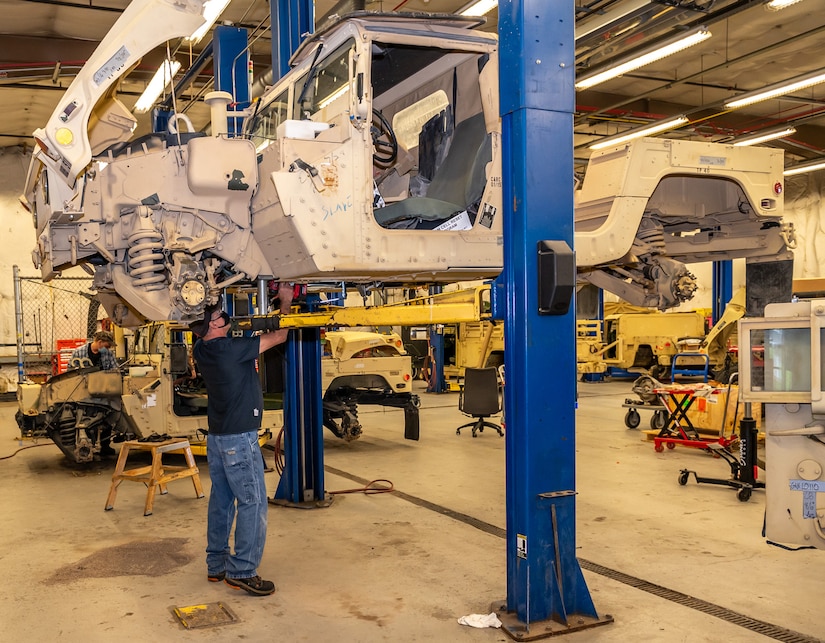 Photo of Canio Lopomo installing a transmission on a High Mobility Multipurpose Wheeled Vehicle (Humvee)