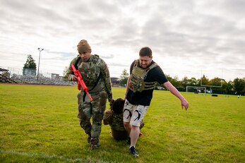 U.S. Air Force Master Sgt. Christian Navarro-Salazar, left, 423rd Security Forces Squadron supply and logistics superintendent, and Luke Young, 423rd SFS resource protection program manager, carry an airmen as part of a defender challenge at RAF Alconbury, England, Oct. 13, 2021. The challenge was part of National Police Week where defenders paid homage to those who have served as police officers and to honor those that lost their lives in the line of duty. (U.S. Air Force photo by Senior Airman Eugene Oliver)