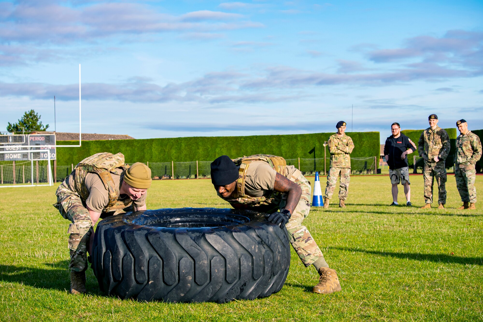 Senior Airman Stone Kraft, left, 423rd Security Forces Squadron installation patrolman, and Staff Sgt. Jaylon Darden, 423rd SFS flight sergeant, flip a tire as part of a defender challenge at RAF Alconbury, England, Oct. 13, 2021. The challenge was part of National Police Week where defenders paid homage to those who have served as police officers and to honor those that lost their lives in the line of duty. (U.S. Air Force photo by Senior Airman Eugene Oliver)