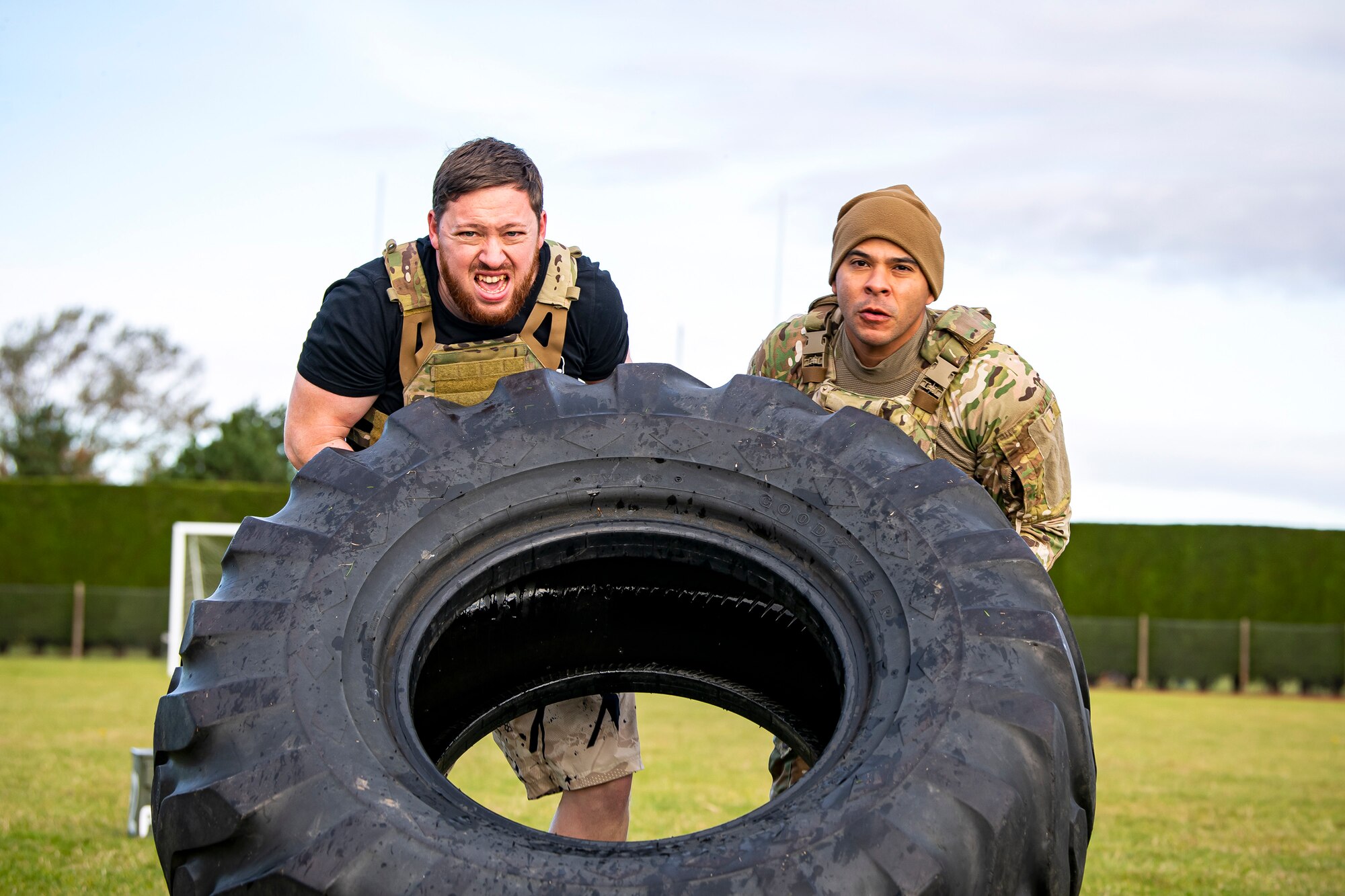 U.S. Air Force Master Sgt. Christian Navarro-Salazar, right, 423rd Security Forces Squadron supply and logistics superintendent, and Luke Young, 423rd SFS resource protection program manager, flip a tire as part of a defender challenge at RAF Alconbury, England, Oct. 13, 2021. The challenge was part of National Police Week where defenders paid homage to those who have served as police officers and to honor those that lost their lives in the line of duty. (U.S. Air Force photo by Senior Airman Eugene Oliver)