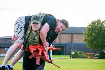 U.S. Air Force Staff Sgt. Meghan Ballard, 423rd Security Forces Squadron NCO in charge of pass and registration, carries Luke Young, 423rd SFS resource protection program manager, as part of a defender challenge at RAF Alconbury, England, Oct. 13, 2021. The challenge was part of National Police Week where defenders paid homage to those who have served as police officers and to honor those that lost their lives in the line of duty. (U.S. Air Force photo by Senior Airman Eugene Oliver)