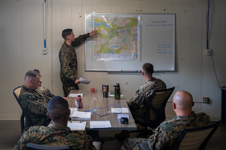 U.S. Marine Corps Capt. Caleb Hoffman-Johnson (center), an infantry officer with 2d Marine Division (MARDIV), presents a battle plan to instructors during the Division Leader Assessment Program (DLAP) at Fort A.P. Hill, Va., Oct. 5, 2021. This program allows division leadership to mentor and assess captains recently assigned to 2d MARDIV on their mental, moral and physical readiness for future command opportunities. This contributes to the division’s mission to train and develop Marines that demonstrate an apex level of lethality, endurance, and comprehensive warfighting ability. (U.S. Marine Corps photo by Cpl. Juan Magadan)