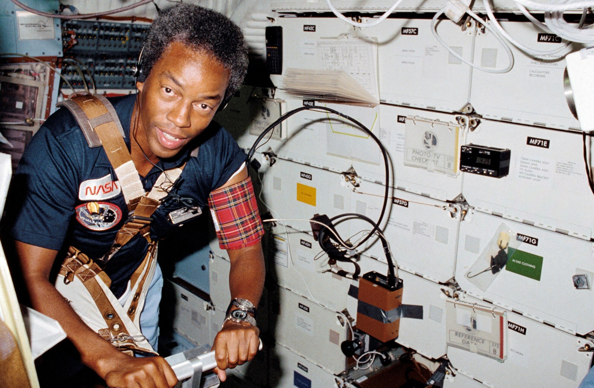 Astronaut Guion S. Bluford, STS-8 mission specialist, assists Dr. William E. Thornton (out of frame) with a medical test that requires use of the treadmill exercising device designed for spaceflight by the STS-8 medical doctor.
