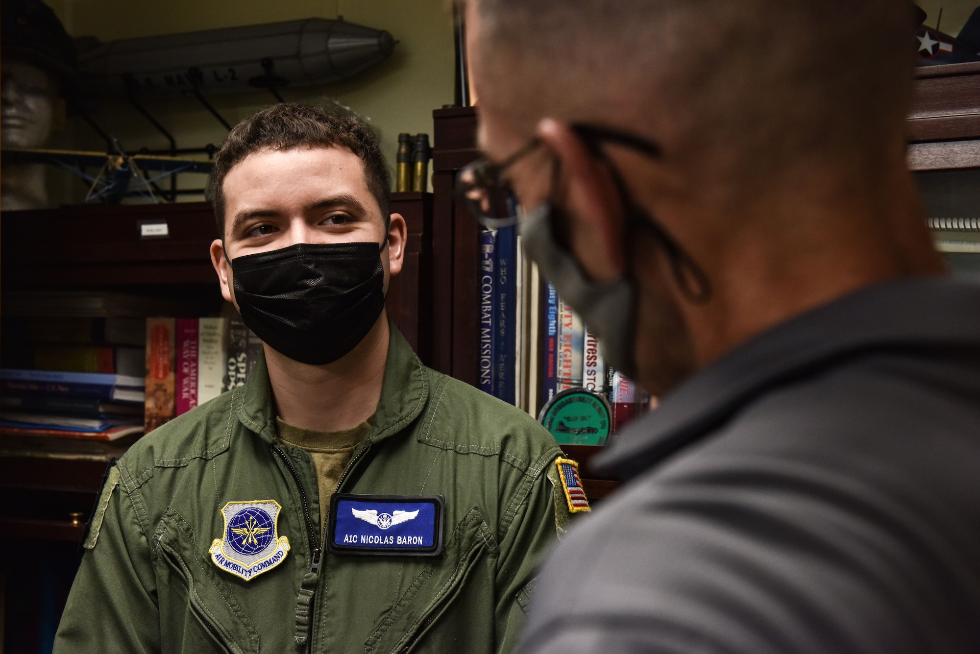 Airman First Class Nicholas Baron, 305th Air Mobility Wing Loadmaster, discusses the details of his blouse with Stuart Lockhart, 305th Air Mobility Wing Historian at Joint Base McGuire-Dix-Lakehurst, N.J., Oct. 12, 2021. The blouse will be sent to the National History Museum of the U.S. Air Force at Wright-Patterson Air Force Base, Ohio. (U.S. Air Force Photo by Staff Sergeant Shay Stuart)
