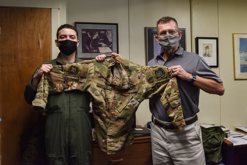 Airman First Class Nicholas Baron, 305th Air Mobility Wing Loadmaster and Stuart Lockhart, 305th Air Mobility Wing Historian, prepare to fold and ship the blouse out of Joint Base McGuire-Dix-Lakehurst, N.J., Oct. 12, 2021. The blouse will keep its original patches making it even more special from an artifacts and preservation perspective. (U.S. Air Force Photo by Staff Sergeant Shay Stuart)