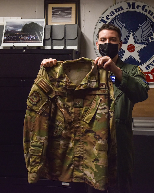Airman First Class Nicholas Baron, 305th Air Mobility Wing Loadmaster, holds his blouse for the last time before donating it to the National History Museum of the U.S. Air Force at Joint Base McGuire-Dix-Lakehurst, N.J., Oct. 12, 2021. Baron’s blouse will go on to be a symbol of Operation Allies Refuge and the humanitarian efforts that were made. (U.S. Air Force Photo by Staff Sergeant Shay Stuart)