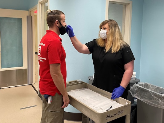Nurse Heather Limerick, U.S. Army Corps of Engineers North Atlantic Division, performs a COVID-19 rapid test on an employee in New Orleans, Louisiana. Both employees were deployed as responders for Hurricane Ida, photo taken Oct.15, 2021.