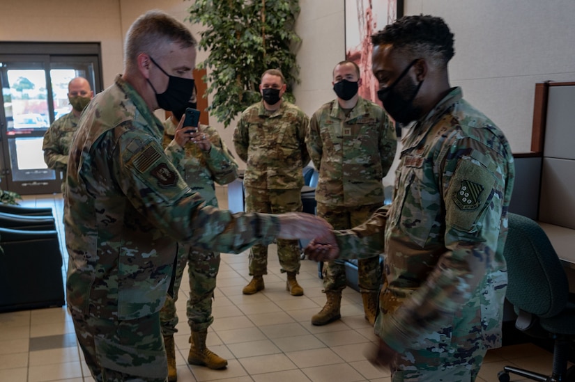 U.S. Air Force Maj. Gen. Michael G. Koscheski (left), Fifteenth Air Force commander, coins Tech. Sgt. Tyrome Conyers