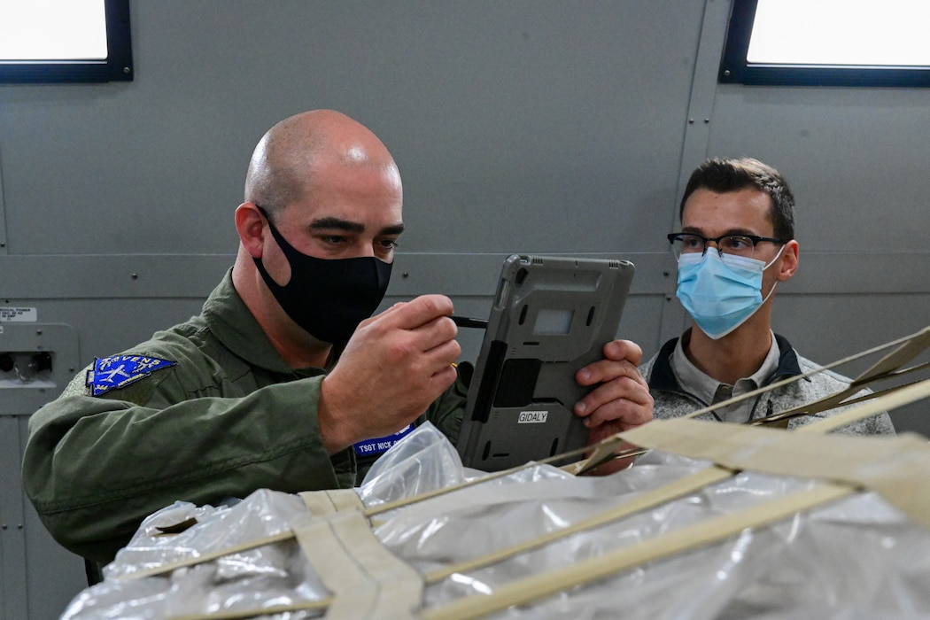 TSgt Nick Gladly, 344th ARS boom operator, demonstrates cargo inspection to Mr. Brett Williams, Boeing cargo stress analysis engineer, Oct. 12, 2021.