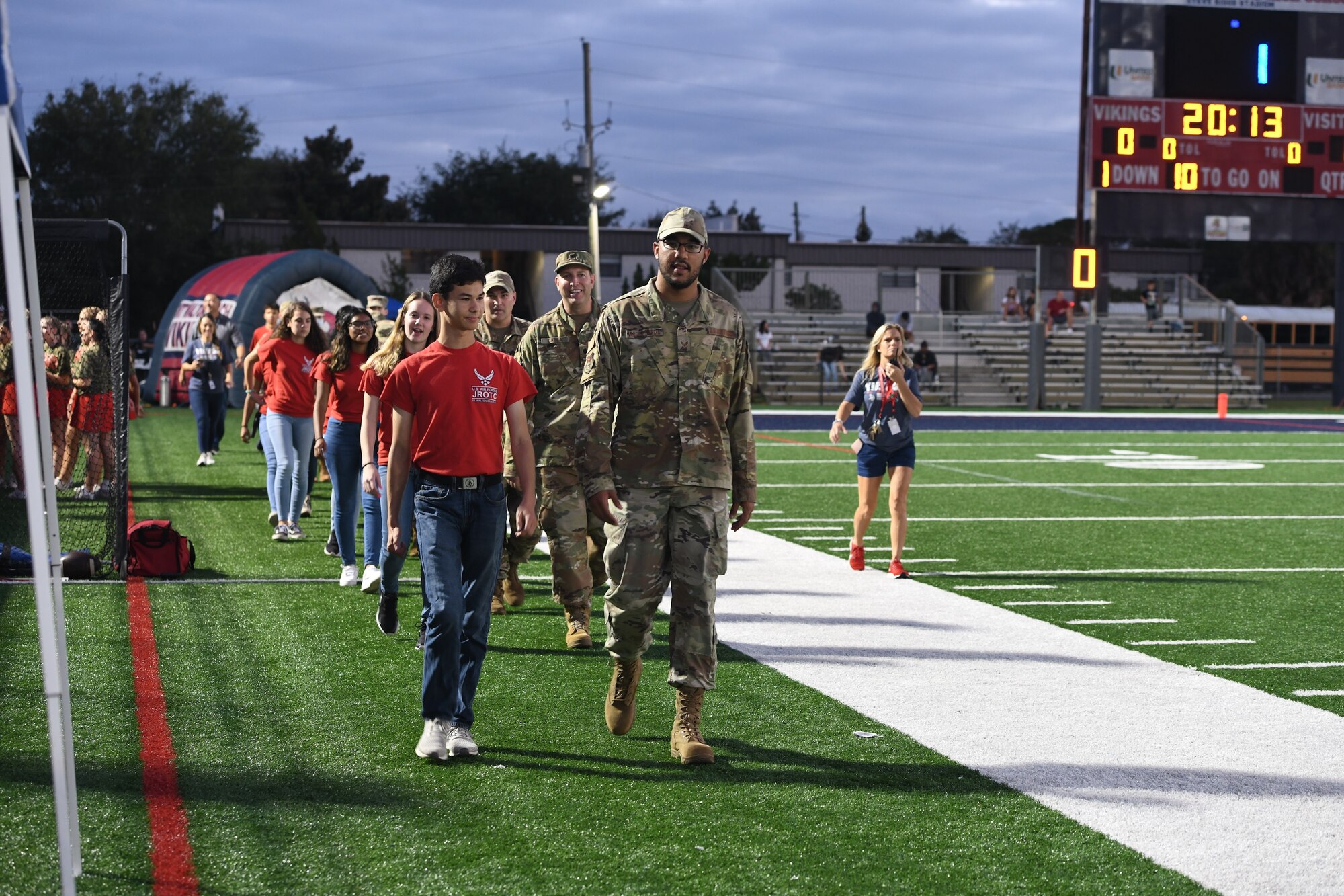 Junior Reserve Officer Training Corps students at Fort Walton Beach High School escort nine Hurlburt Field Airmen to center field during the 2021 Military Appreciation football game in Fort Walton Beach, Florida, on October 7th, 2021. These Airman from the 1st Special Operations Medical Group were recognized for their help with COVID-19 mitigation efforts. (U.S. Air Force photo by Staff Sgt. Tarelle Walker)