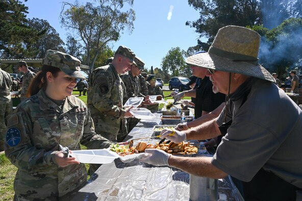 Man serving a military member food outside