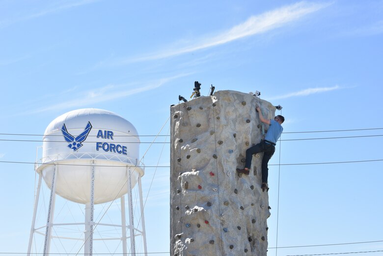 A Goodfellow member climbs a rock-wall during the Oktoberfest at Goodfellow celebration at the Event Center Complex on Goodfellow Air Force Base, Texas, Oct. 16, 2021. The celebration included live music, German food, rock climbing, and other family-friendly activities. (U.S. Air Force photo by Senior Airman Ashley Thrash)