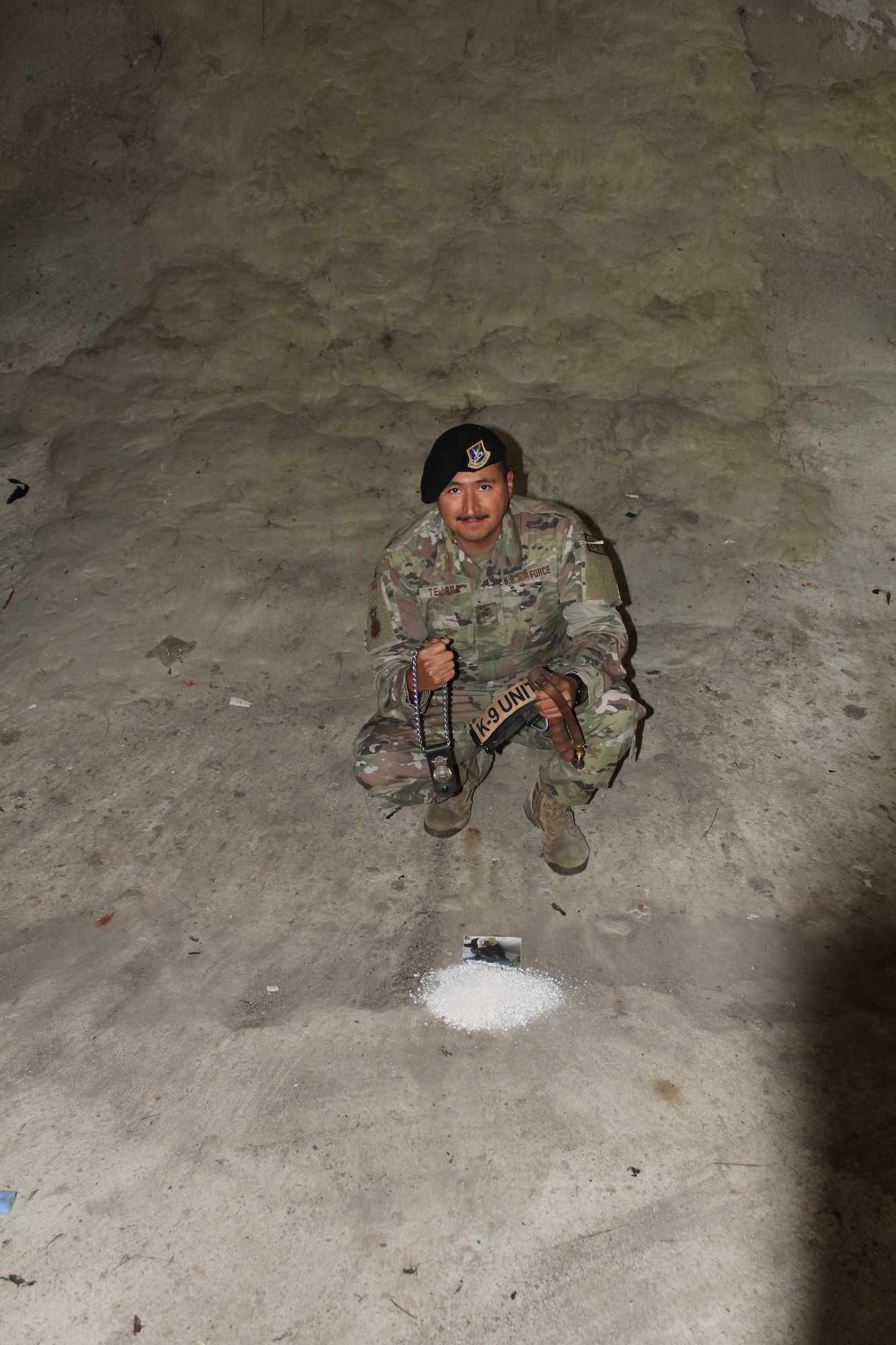 U.S. Air Force Tech. Sgt. Joseph Tejada, 30th Security Forces Squadron alpha flight sergeant, pours the ashes of his furry companion, Military Working Dog Sam, and holds mementos of his adventurous life on Vandenberg Space Force Base, Calif., Sept. 27, 2021. His ashes were dispersed in the blast tunnel underneath the ULA Atlas V rocket for the Vandenberg’s 2000th launch. (Courtesy photo by Tech. Sgt. Joseph Tejada)