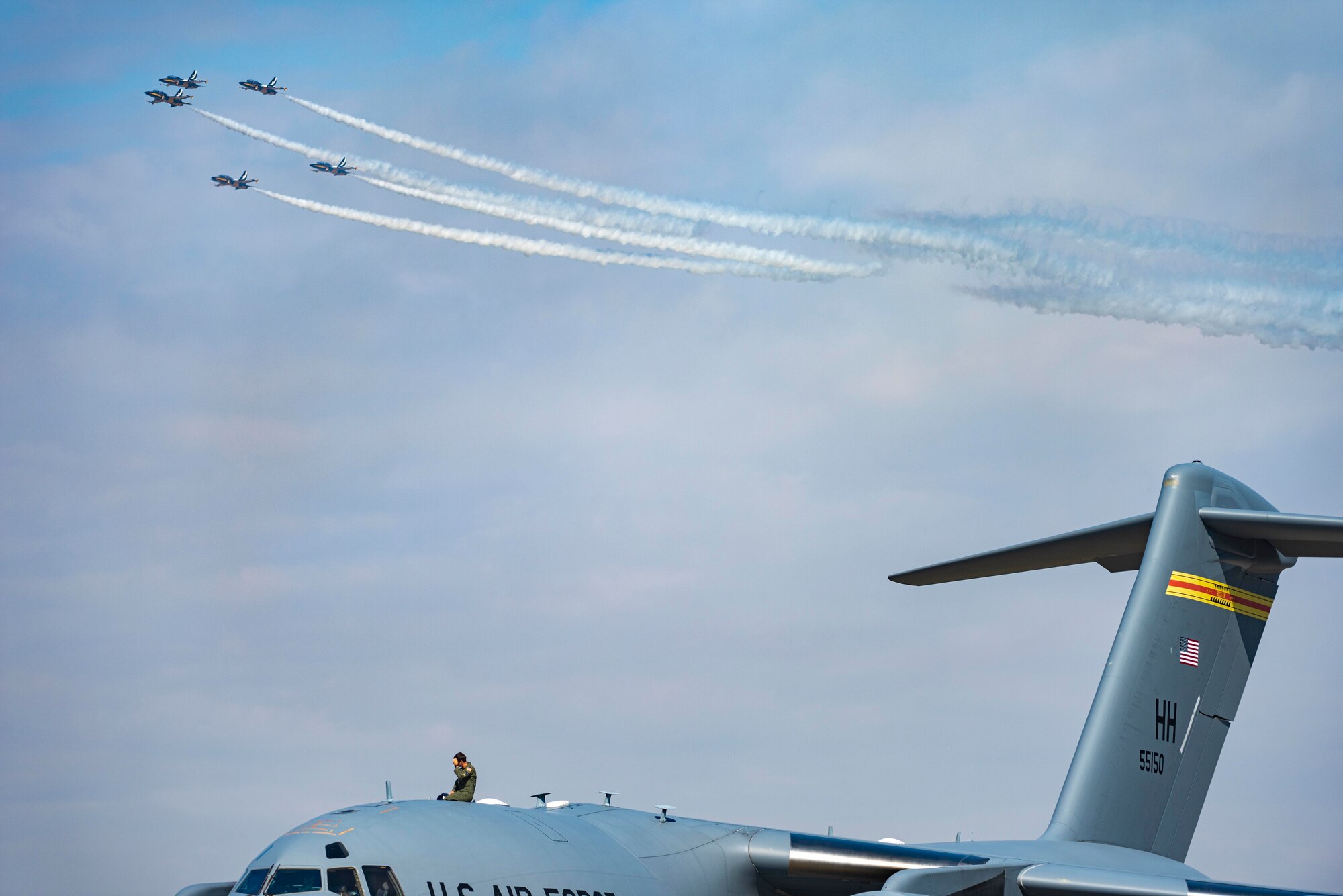 A U.S. military member watches as the Republic of Korea Air Force Black Eagles perform during the Seoul International Aerospace and Defense Exhibition 2021 at Seoul Air Base, ROK, Oct. 18. Seoul ADEX 21 is the largest, most comprehensive event of its kind in Northeast Asia, attracting aviation and industry professionals, key defense personnel, aviation enthusiasts and the general public alike. (U.S. Air Force photo by Staff Sgt. Gabrielle Spalding)