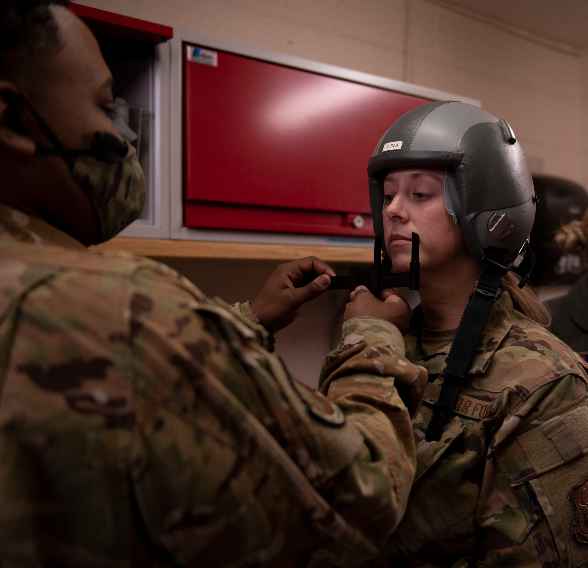 an airman measures another airmans face for an oxygen mask