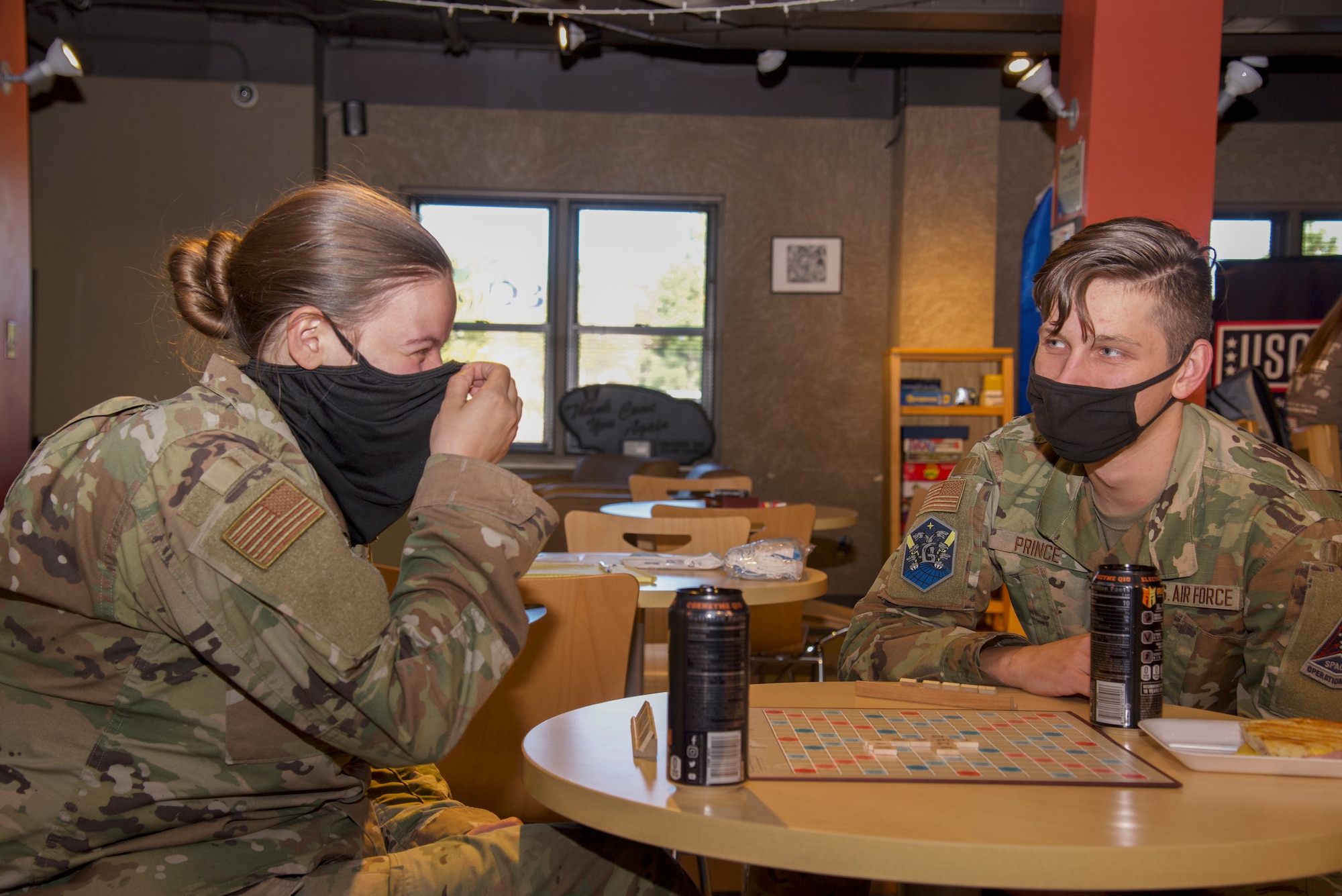 U.S. Air Force Airman 1st Class Alexis Christian and U.S. Air Force Airman 1st Class Ryan Prince, Peterson-Schriever Garrison Public Affairs mass communication specialists, play Scrabble at the Eclipse Café on Peterson Space Force Base, Colorado, Oct. 5, 2021.