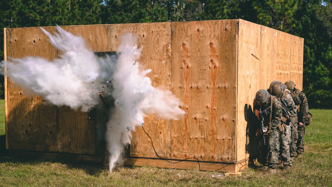 U.S. Marines with 2nd Combat Engineer Battalion, 2nd Marine Division, breach through a door during urban breaching training as part of the Sapper Leader’s Course 1-22 on Camp Lejeune, N.C., Oct. 16, 2021. The Sapper Leader’s Course gives students hands-on experience preparing explosives, breaching, clearing buildings, and working as a team through obstacles.