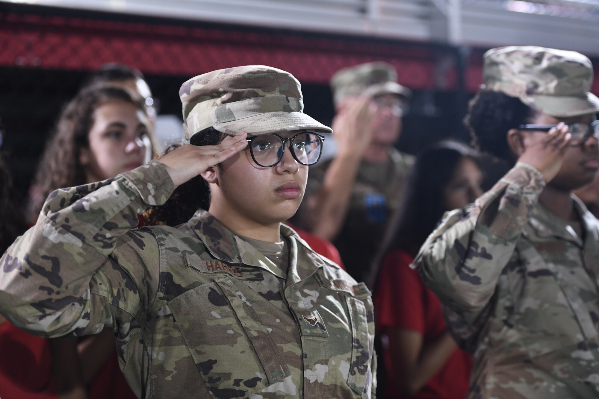 U.S. Air Force Airman 1st Class Shayla Harris, a member of the Health Services Management team in the 1st Special Operations Wing at Hurlburt Field, Florida, salutes during the playing of the national anthem at the opening of a Military Appreciation football game in Fort Walton Beach, Florida, October 7th. Harris was one of nine Airmen who was recognized for her efforts for the COVID mitigation game. (U.S. Air Force photo by Staff Sgt. Tarelle Walker)