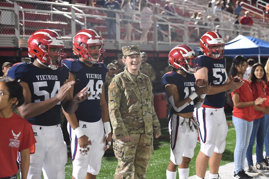 Varsity football players welcome U.S Air Force Col. Jocelyn Schermerhorn, commander of the 1st Special Operations Wing, Hurlburt Field, Florida, during the 2021 Military Appreciation football game at Fort Walton Beach High School on October 7th, 2021. Schermerhorn was invited to do the opening coin toss at the start of the Fort Walton Beach vs. Escambia game. (U.S. Air Force photo by Staff Sgt. Tarelle Walker)