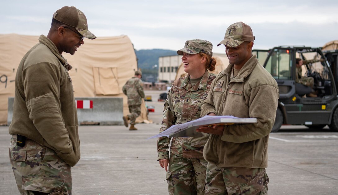 U.S. Air Force 1st Lt. Gabriel Houston, right, 786th Civil Engineer Squadron engineering chief and 1st Lt. Merrick Choate-Houston, middle, 86th CES installation management flight deputy, coordinates with Tech. Sgt. Brandon Hudson, left, 635th Material Maintenance Squadron bare base team lead, assigned to Holloman Air Base, New Mexico, about the reconstitution and tear down of Pod One at Ramstein Air Base, Germany, Oct. 13, 2021. After leading the way for the creation and sustainment of pod operations, the Houstons are now supporting the tear down of the pods as the evacuees leave for other transient locations. (U.S. Air Force photo by Airman Jared Lovett)