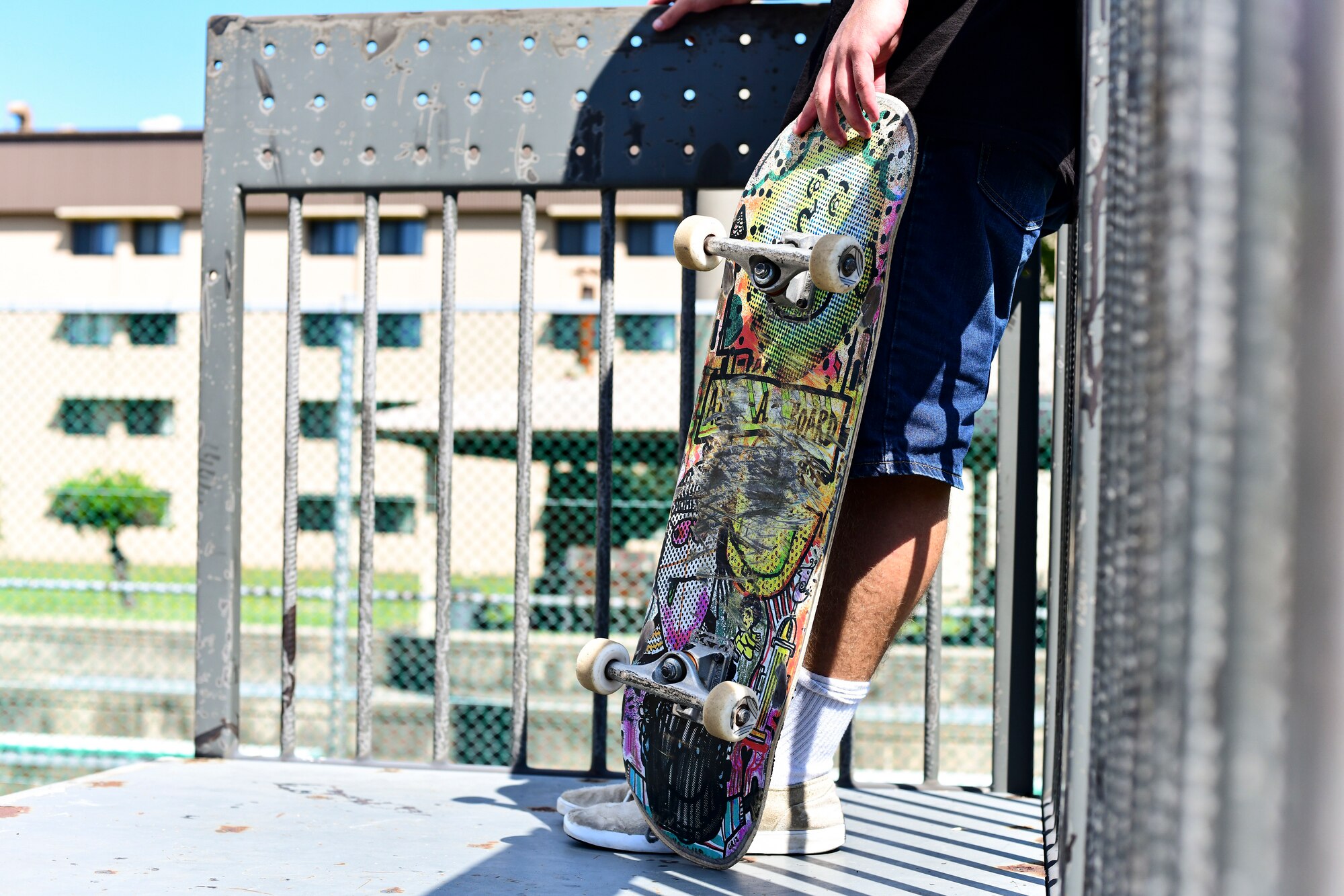 An Airman holds his skateboard.
