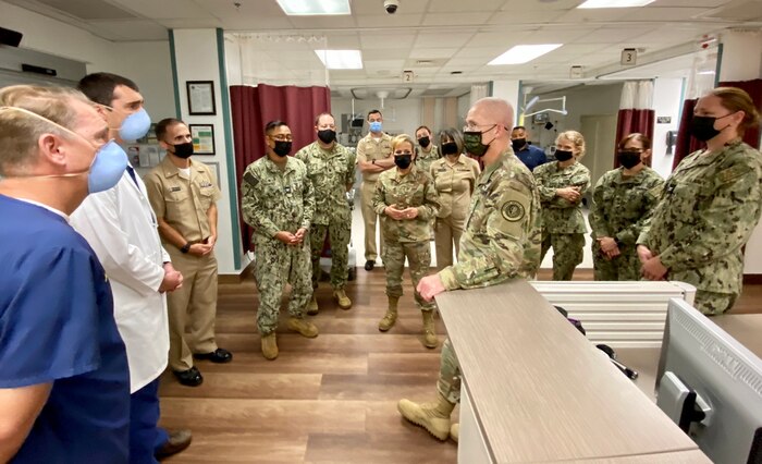 Defense Health Agency Director U.S. Army Lt. Gen. Ronald Place speaks with Lt. Patrick Bagley, an emergency room provider, during an evening tour of the U.S. Naval Hospital Guantanamo Bay and U.S. Navy Medicine Readiness and Training Command, Oct. 6.