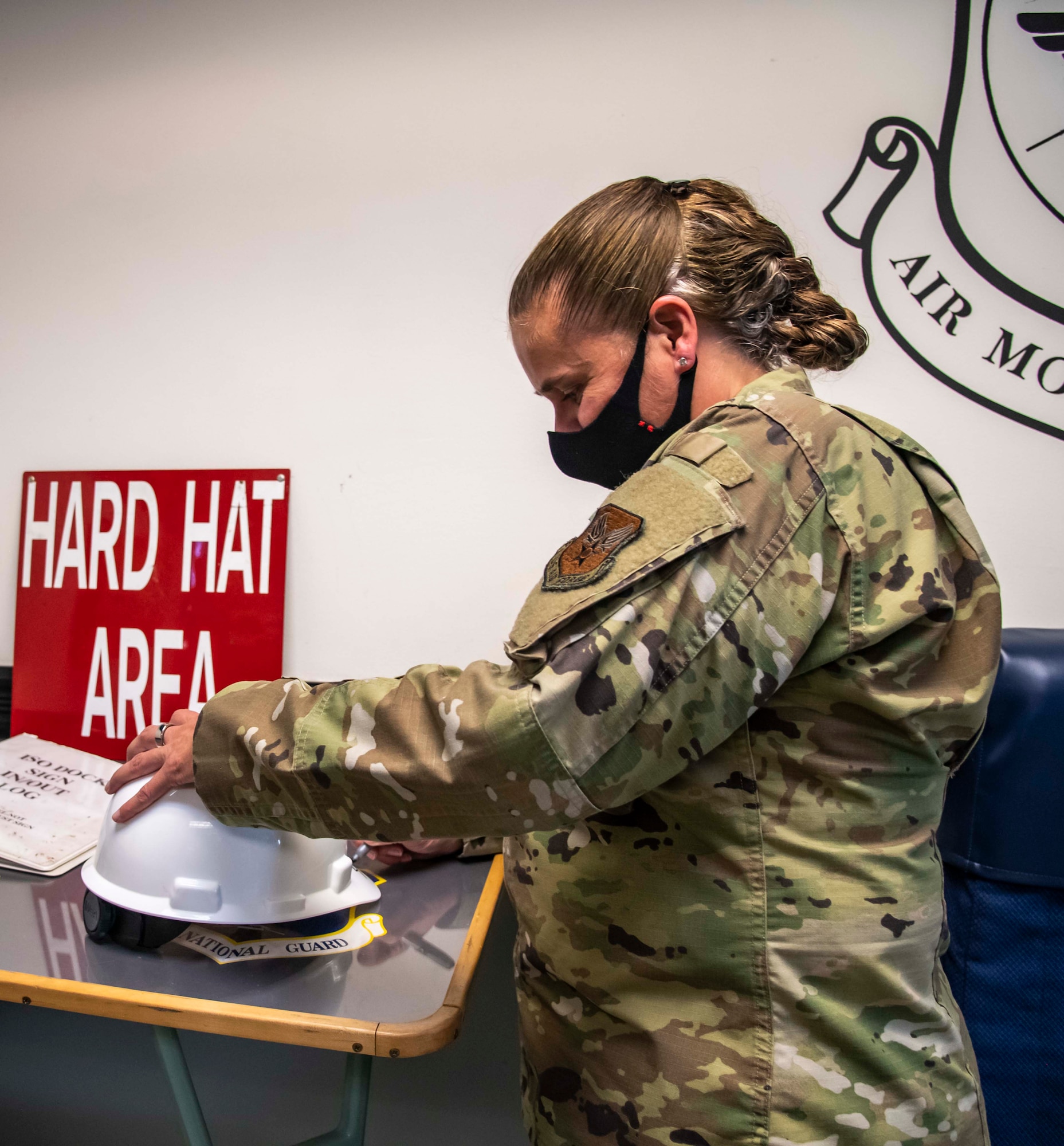 Maj. Gen. Linda Hurry, director of logistics for the Deputy Chief of Staff for logistics, engineering and force protection, signs a hard hat while touring the Isochronal Maintenance Dock at Dover Air Force Base, Delaware, Oct. 14, 2021. Hurry toured the aerial port, ISO Dock and DMS to evaluate how she can best support the Airmen. (U.S. Air Force photo by Senior Airman Stephani Barge)