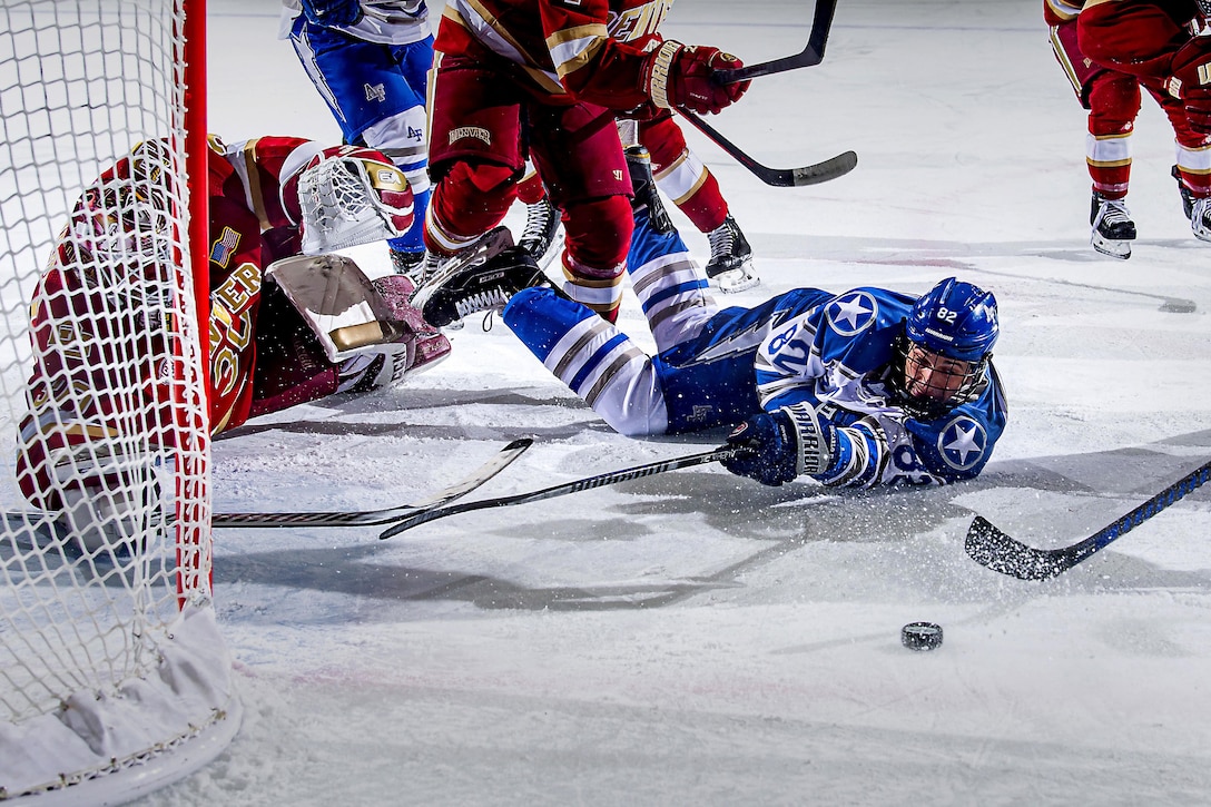 A hockey player lies on the ice after hitting a puck.