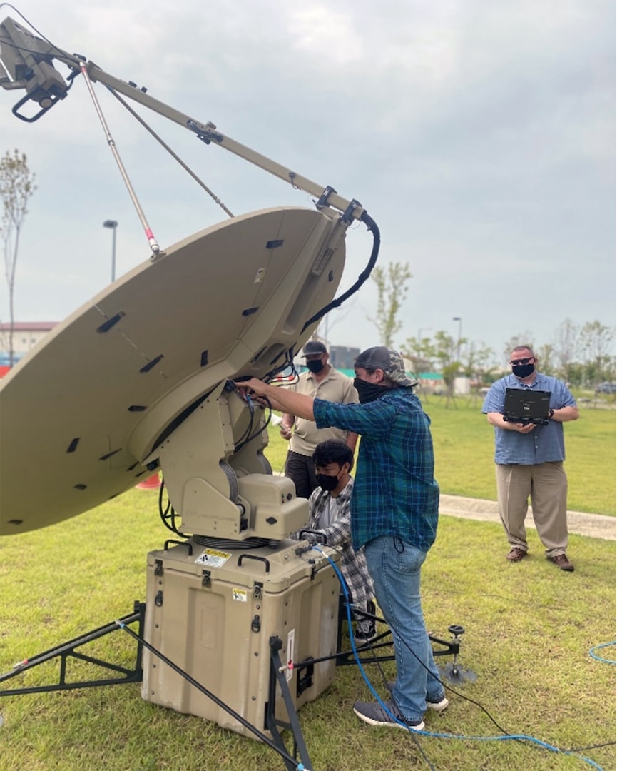 Four men check the condition of a satellite dish during the Combined Command Post Exercise that took place on the Korean Peninsula.