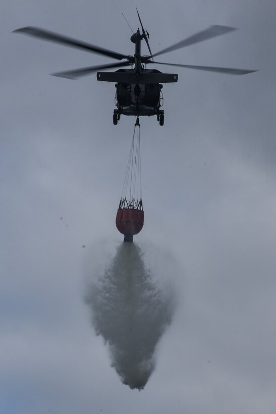 Virginia Army National Guard flight crews conduct water bucket training with UH-60 Black Hawk helicopters Oct. 12, 2021, at a training area in Chesterfield, Virginia. Aviation assets can support fire-fighting efforts with the use of water buckets, which require periodic training for flight crews in order to ensure equipment proficiency. These Soldiers are scheduled to deploy to Kosovo with the Sandston-based 2nd Battalion, 224th Aviation Regiment, 29th Infantry Division in early 2022, where fire-fighting capabilities may be needed. (U.S. Army National Guard photo by Sgt. 1st Class Terra C. Gatti)