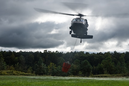 Virginia Army National Guard flight crews conduct water bucket training with UH-60 Black Hawk helicopters Oct. 12, 2021, at a training area in Chesterfield, Virginia. Aviation assets can support fire-fighting efforts with the use of water buckets, which require periodic training for flight crews in order to ensure equipment proficiency. These Soldiers are scheduled to deploy to Kosovo with the Sandston-based 2nd Battalion, 224th Aviation Regiment, 29th Infantry Division in early 2022, where fire-fighting capabilities may be needed. (U.S. Army National Guard photo by Sgt. 1st Class Terra C. Gatti)