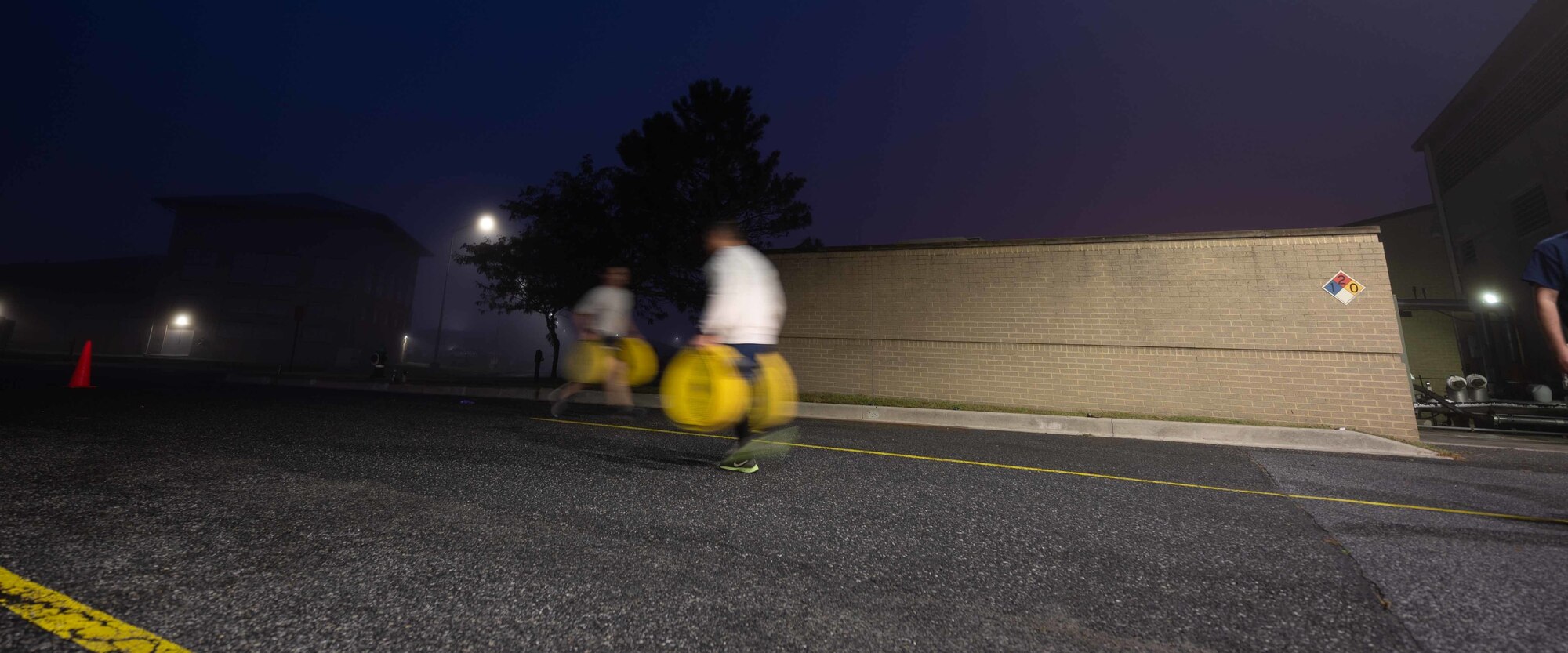 Airmen from the 436th Civil Engineer Squadron perform farmer carries during a physical training session at the firehouse on Dover Air Force Base, Delaware, Oct. 14, 2021. The Dover AFB fire department hosted a firefighter centric workout for squadron members that featured farmer carries, hose drags and ladder climbs, as part of Fire Prevention Week 2021. (U.S. Air Force photo by Senior Airman Faith Schaefer)