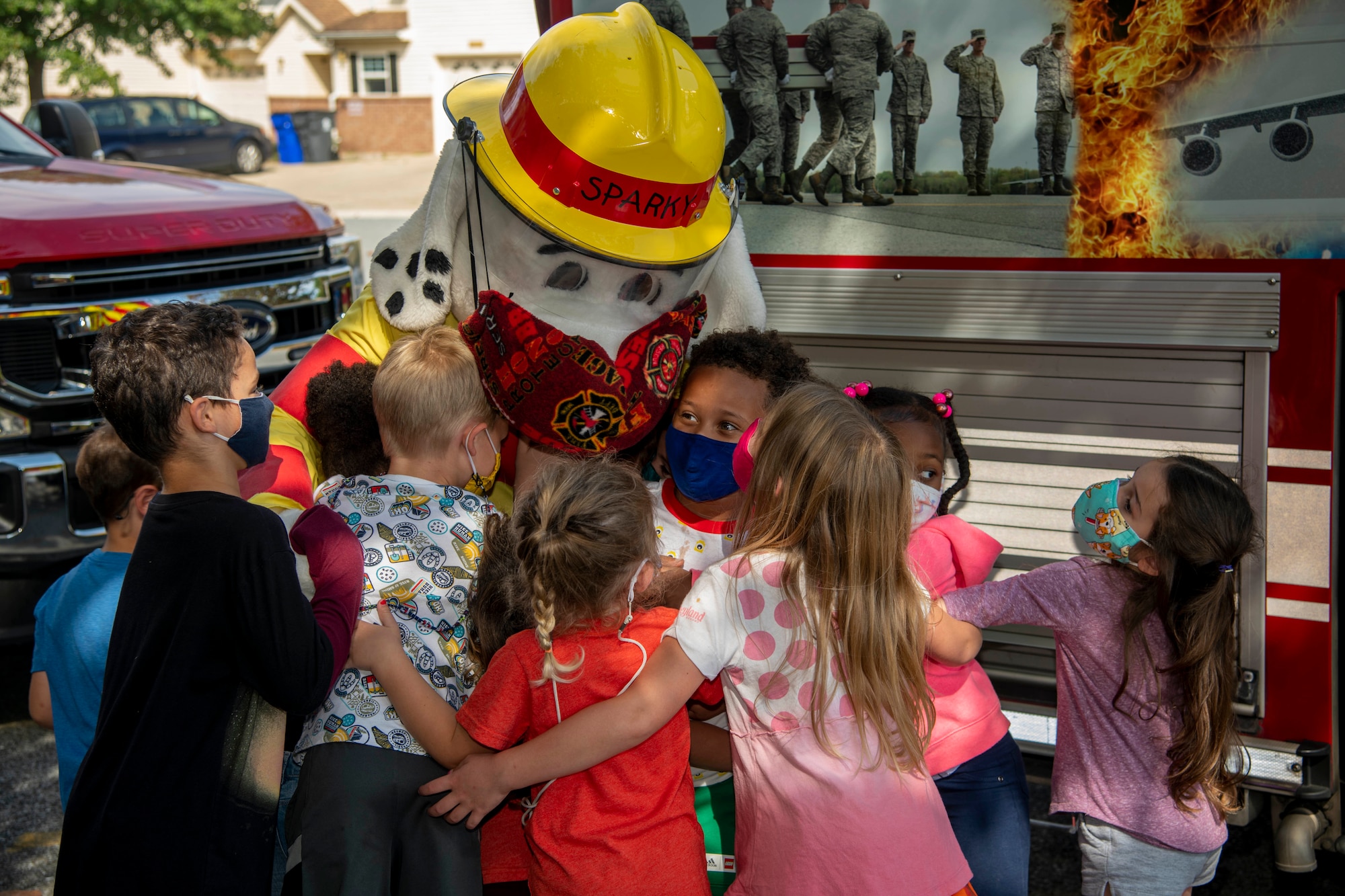 Students from Major George S. Welch Elementary School give Sparky the Fire Dog a hug after learning about fire safety during a visit for Fire Prevention Week on Dover Air Force Base, Delaware, Oct. 15, 2021. Fire Prevention Week is an annual observance to educate the Dover AFB community about the importance of fire prevention. (U.S. Air Force photo by Tech. Sgt. Nicole Leidholm)